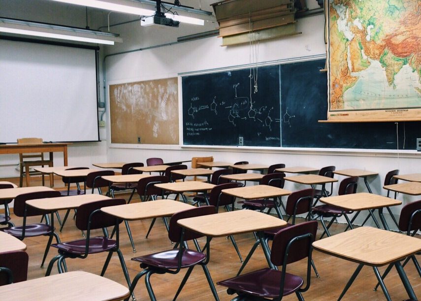 Rows of empty desks in a classroom