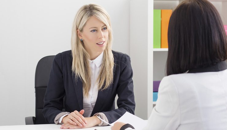 Two business women discuss in an office