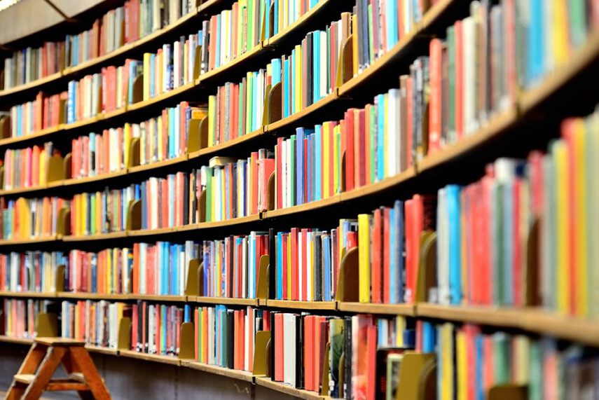 Rows of full stacks of colorful books in library