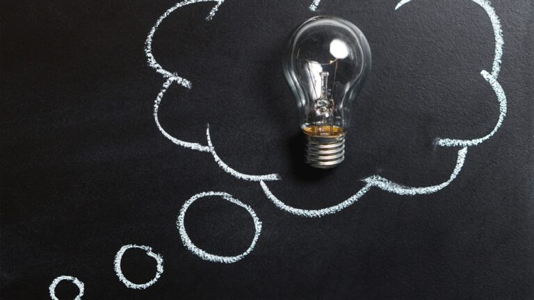 Light bulb against a chalkboard with a thought bubble drawn around it