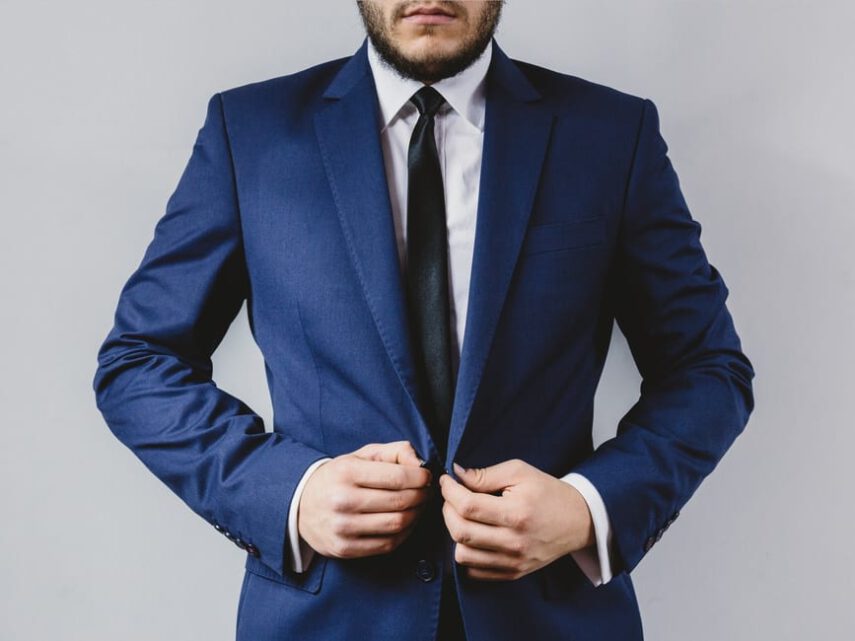business man puts on his blue suit jacket