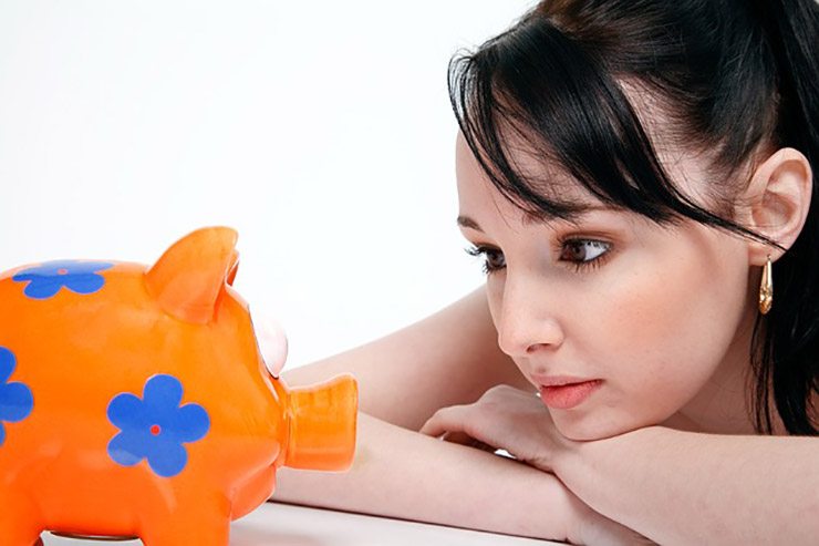 woman stares at orange and blue flowered piggy bank