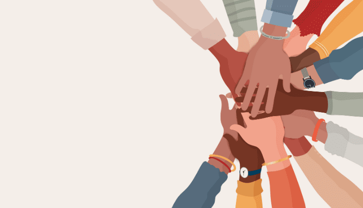 Diverse group of hands stacked together, symbolizing unity and teamwork against a plain background.