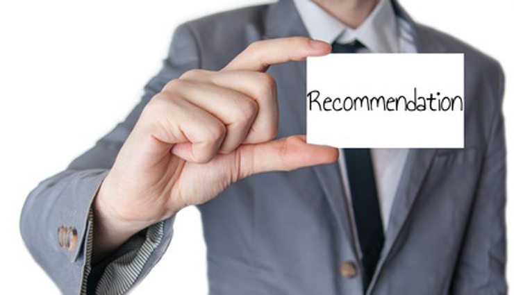 Man in suit holds index card reading "Recommendation"