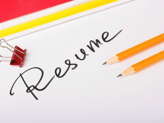 office supplies and "resume" written on white board in black