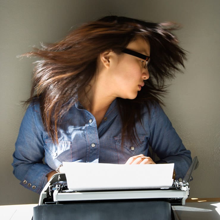 girl types on typewriter flipping hair