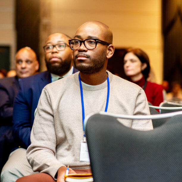 Audience members attentively listening to a presentation at a conference.