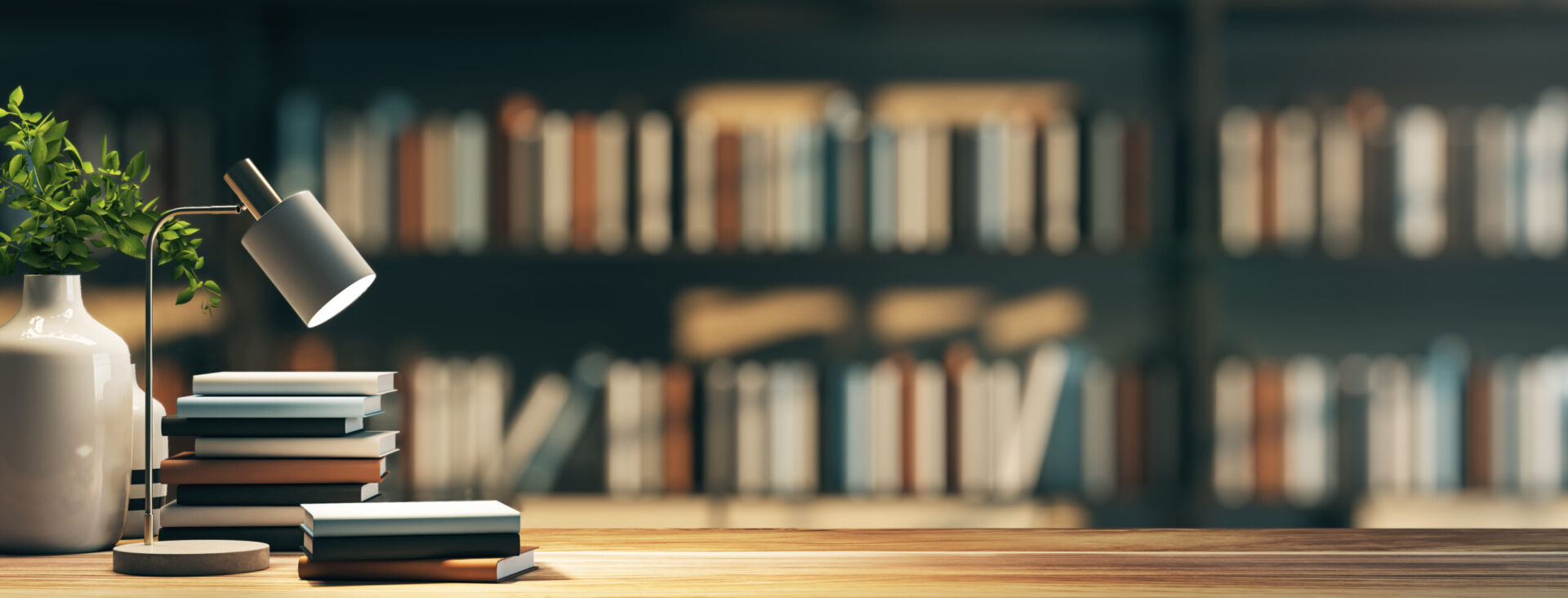 Cozy library scene with a stack of books and a desk lamp on a wooden table, blurred shelves in the background.